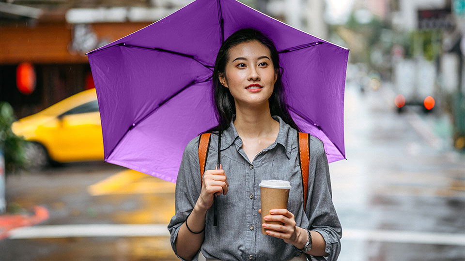 Woman holding a coffee and purple umbrella